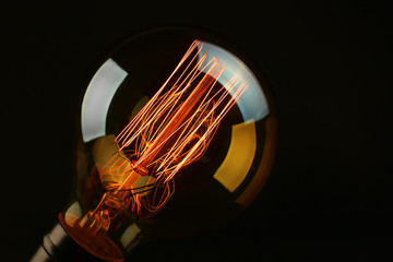 Illuminated light bulb on black background