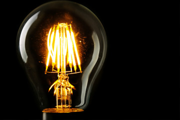 Illuminated light bulb on black background
