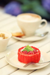 Strawberry biscuit cake in white plate on light wooden table
