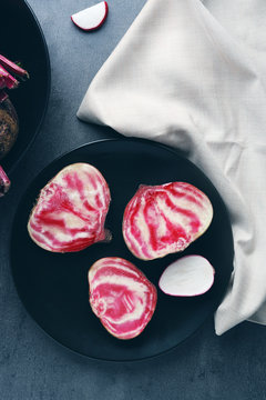 Beet slices with radishes on grey table