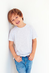 handsome young boy, kid posing near the white wall