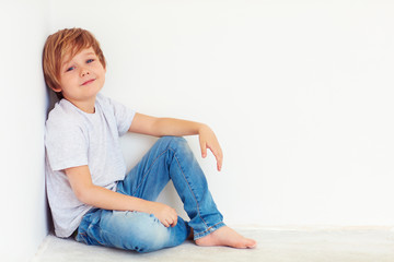 handsome young boy, kid posing near the white wall