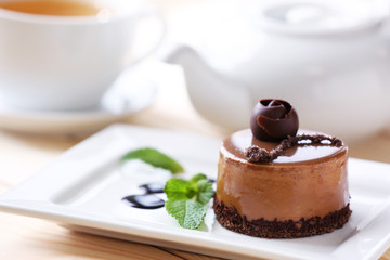 Caramel cake with tea on wooden table