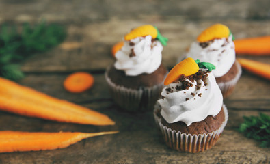 Carrot chocolate muffins on a wooden background