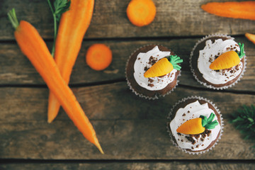 Carrot chocolate muffins on a wooden background