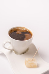 White cup of coffee with turkish delight over white background w