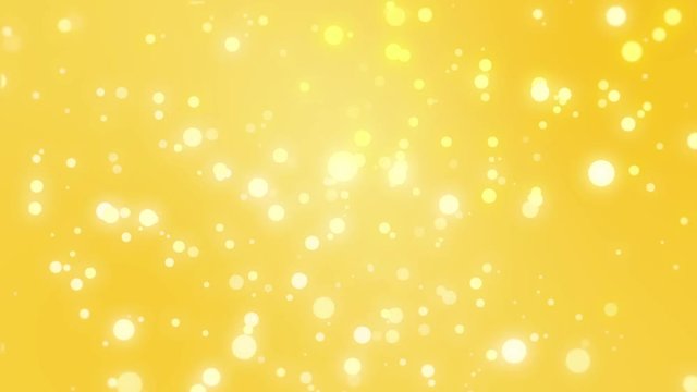 Sparkly light particles moving across a gold yellow gradient background