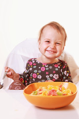 little baby girl eating with a spoon