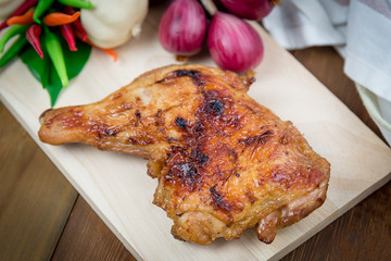 Grill chicken thighs with vegetables of wooden plate.Selective focus