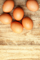 The image of eggs on a wooden table.