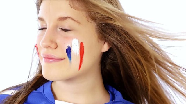 Girl with French flag on her face smiling
