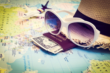 Obraz premium Sunglasses, Passport, Money, Hat and aircraft on the world map