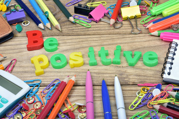 Be positive and office tools on wooden table