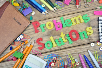 Problems Solutions words and office tools on wooden table