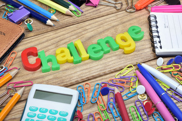 Challenge word and office tools on wooden table