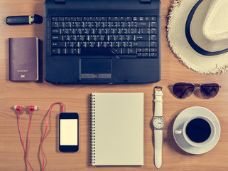 Obraz na płótnie Canvas Office desk with computer, supplies, coffee cup, passport, hat,