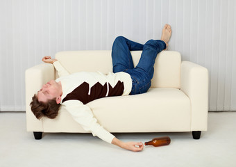 Drunkard sleeps on sofa in an amusing pose