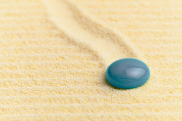 Abstract composition - sandy surface and blue glass drop