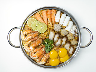 Bowl of spicy instant noodles isolated on white background. Topping with eggs, lemon, pork , crispy pork, sausage and coriander