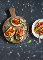 Sandwiches with quick ratatouille on rustic cutting board on a dark background. Delicious healthy...