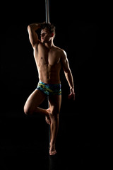 Male pole dance. Photo of muscular man posing