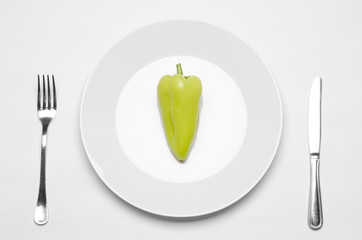 Healthy eating in the restaurant and diet Topic: beautiful ripe green pepper on a white plate and a...