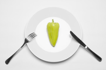 Healthy eating in the restaurant and diet Topic: beautiful ripe green pepper on a white plate and a...
