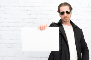 mann mit sonnenbrille zeigt hinweisschild