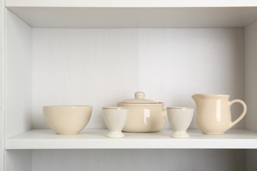 Fototapeta na wymiar Tableware on shelf in the kitchen cupboard