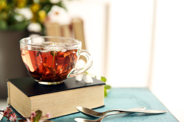 Cup of tea with book on wooden stool