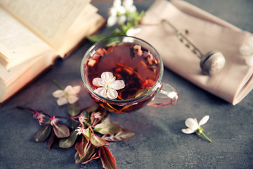 Cup of tea with flowers on brown table