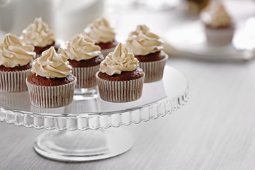 Tasty cupcakes on glass stand