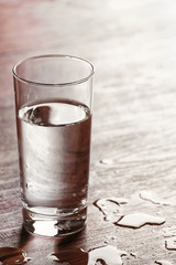Filled glass of water on wooden background