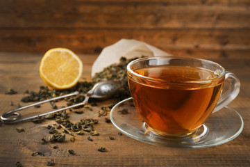 Cup of black tea with lemon on wooden table