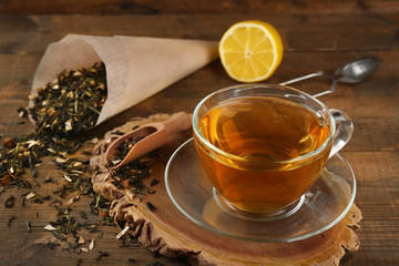 Cup of black tea with lemon on wooden table