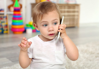 Cute baby girl playing with a smartphone