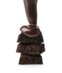 Melted chocolate pouring on chocolate bar, isolated on white