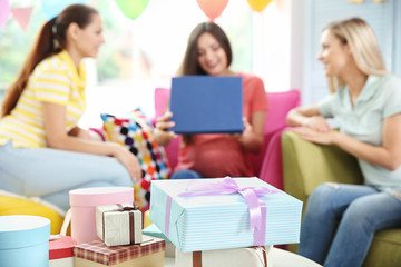 Presents and pregnant woman with friends at baby shower party