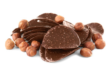 Chocolate chips and hazelnuts on white background