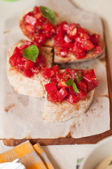 Italian tomato bruschetta with chopped vegetables, herbs and oil on grilled or toasted crusty ciabatta bread