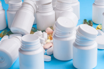 Many pills and tablets isolated on light blue background