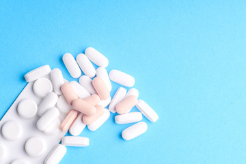 Many pills and tablets isolated on light blue background
