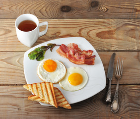 English Breakfast - scrambled eggs, bacon, fried toast and tea