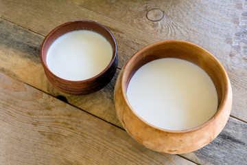 fresh milk in a wooden bowl on the table