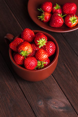 strawberry in a cup on wooden background, top view
