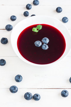 blueberry soup on wooden white background, top view