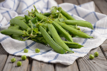 Fresh green peas on rustic wooden background, selective focus