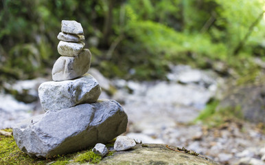 Stack of pebble stones by a stream in a forest