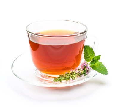 Cup of black tea with mint leaves and flower