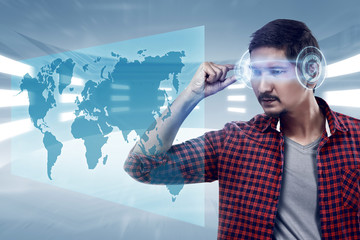 Young man looking world map with futuristic smart high tech glasses